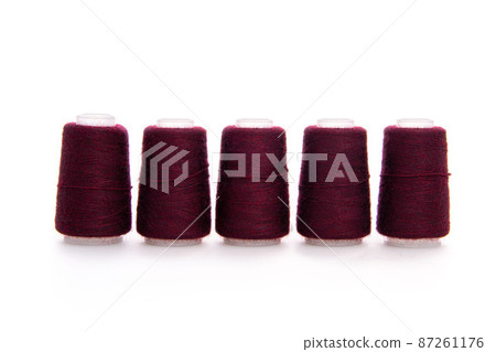 Red spool of thread isolated on white background. Skein of woolen threads. Yarn for knitting. Materials for sewing machine. Coil. Red spool of thread isolated on white background. Skein of woolen threads. Yarn for knitting. Materials for sewing machine. Coil. 87261176