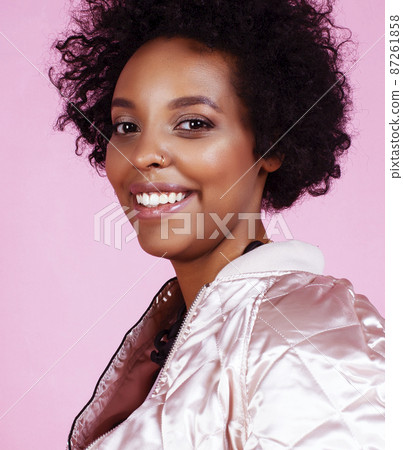 young pretty fashion styled african girl posing emotional cheerful on pink background, lifestyle people concept 87261858