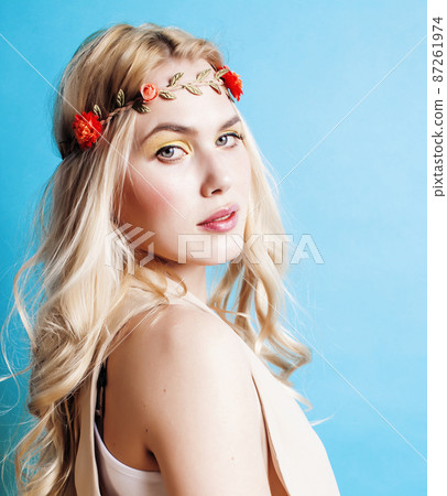 young blond woman dressed like ancient greek godess, beautiful girl hands manicured red nails on blue background copyspace 87261974
