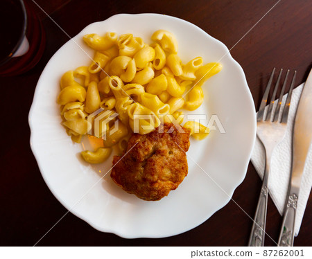 Dish of Russian cuisine is a meat cutlet with macaroni Dish of Russian cuisine is a meat cutlet with macaroni 87262001