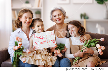 Happy International Womens Day. family grandmother, mother and daughter with flowers and a poster celebrate holiday  87262205