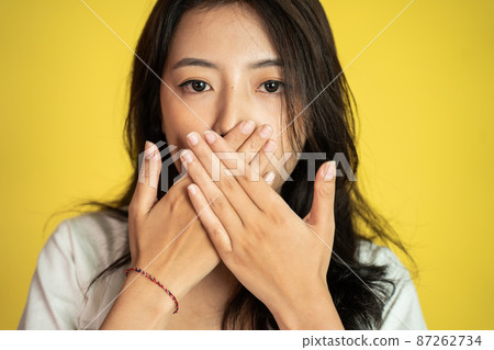 asian woman covering her mouth with hands asian woman covering her mouth with hands 87262734