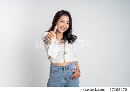smiling young woman stand with thumbs up on isolated background 87262976