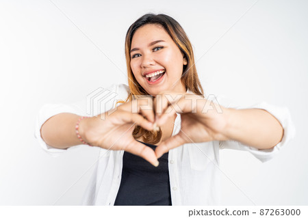 young woman laughing with heart shape with fingers young woman laughing with heart shape with fingers 87263000
