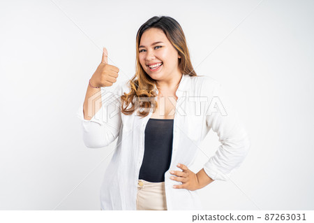 smiling young woman stand with thumbs up on isolated background 87263031