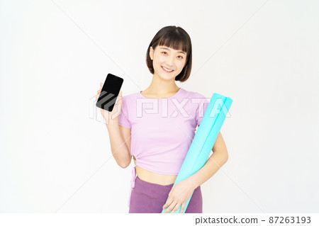 A woman holding a smartphone in sportswear A woman holding a smartphone in sportswear 87263193