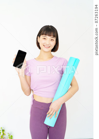 A woman holding a smartphone in sportswear 87263194