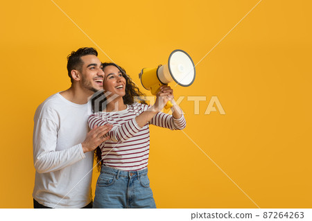 Nice Promo. Cheerful Arab Couple Using Megaphone For Making Announcement Nice Promo. Cheerful Arab Couple Using Megaphone For Making Announcement 87264263