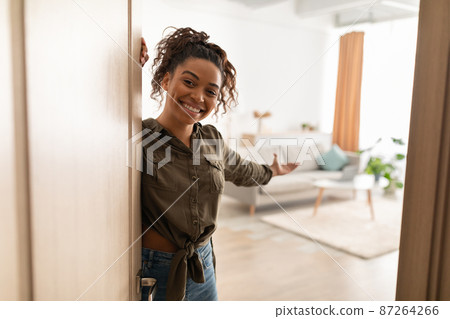 Joyful Millennial Black Lady Opening Door Welcoming Standing At Home Joyful Millennial Black Lady Opening Door Welcoming Standing At Home 87264266