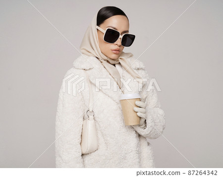 Beautiful young lady in a white faux fur coat 87264342