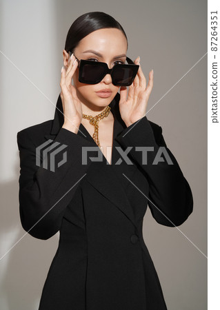 Beautiful young lady in a black pantsuit Beautiful young lady in a black pantsuit 87264351