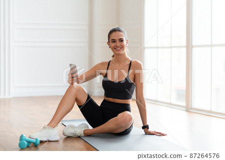 Fitness lady listening to music during break Fitness lady listening to music during break 87264576
