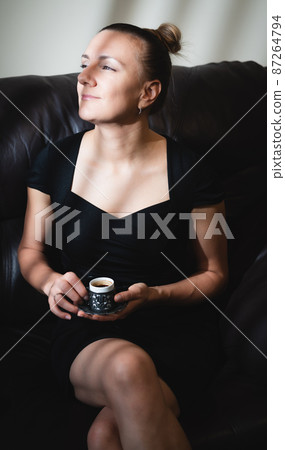 young woman enjoying a cup of coffee 87264794