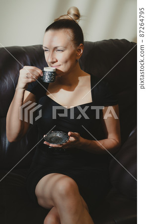 young woman enjoying a cup of coffee 87264795
