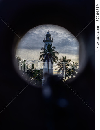 Lighthouse at Galle dutch fort view through a round hole. 87264819