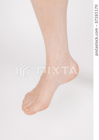 Barefoot and legs isolated on white background. Closeup shot of healthy beautiful female feet. Health and beauty concept. Side view of human foot ream with neutral manicure or pedicure. Sole of foot. 87265170