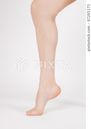 Barefoot and legs isolated on white background. Closeup shot of healthy beautiful female feet. Health and beauty concept. Side view of human foot ream with neutral manicure or pedicure. Sole of foot. Barefoot and legs isolated on white background. Closeup shot of healthy beautiful female feet. Health and beauty concept. Side view of human foot ream with neutral manicure or pedicure. Sole of foot. 87265173