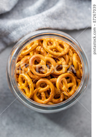 Mini pretzels. Crusty salted snack in bowl. 87267039