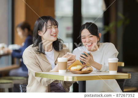 Young woman smartphone spending time in a cafe Young woman smartphone spending time in a cafe 87267352