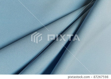Blue crumpled or wavy fabric texture background. Abstract linen cloth soft waves. Gabardine wool fabric. Merino yarn. Smooth elegant luxury cloth texture. Concept for banner or advertisement. Blue crumpled or wavy fabric texture background. Abstract linen cloth soft waves. Gabardine wool fabric. Merino yarn. Smooth elegant luxury cloth texture. Concept for banner or advertisement. 87267598