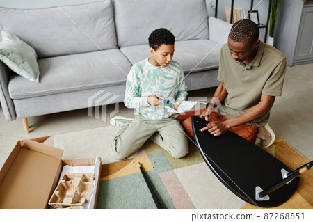 Father and Daughter Assembling Furniture Together 87268851