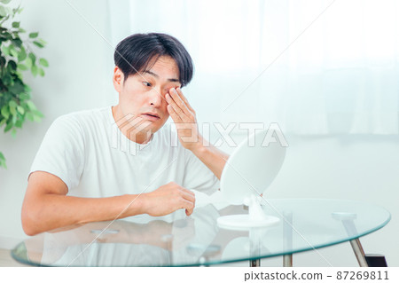 Man looking in the mirror (eyes) 87269811