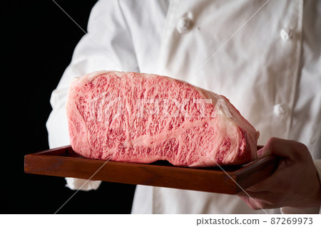 一個廚師手裡拿著一塊日本黑牛里脊牛排 一個廚師手裡拿著一塊日本黑牛里脊牛排 87269973