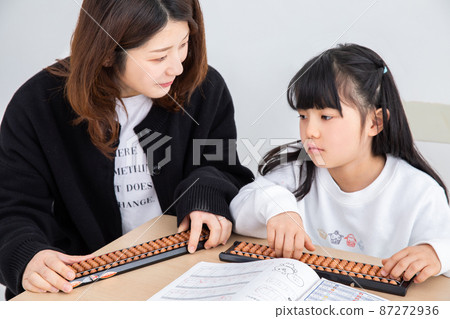 Mother and daughter learning abacus homework 87272936