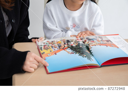 Parent and child reading aloud a picture book 87272948