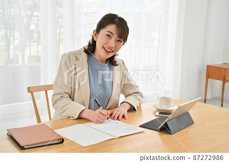 A woman wearing a jacket and doing disc work in the room 87272986