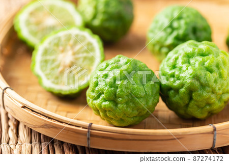 Organic Kaffir lime in bamboo basket, Citrus fruit used in Southeast Asian cuisine and essential oil Organic Kaffir lime in bamboo basket, Citrus fruit used in Southeast Asian cuisine and essential oil 87274172