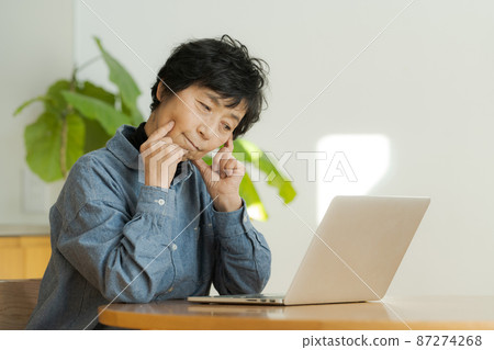 Female senior operating a personal computer Female senior operating a personal computer 87274268
