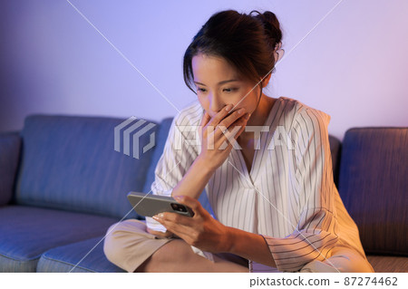 A woman relaxing at home at night A woman relaxing at home at night 87274462