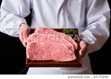 手拿肉的日本黑牛里脊牛排板前 手拿肉的日本黑牛里脊牛排板前 87274894