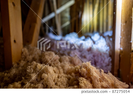 Dark attic with loose blown insulation seen throughout.  87275054