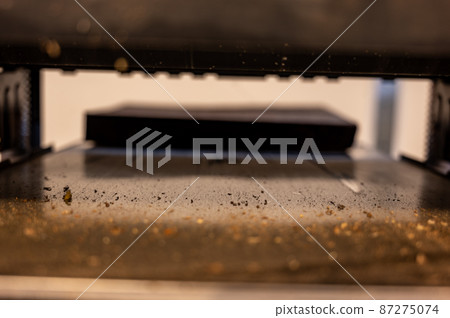 Selective focus looking into a wood planer bed raised above the board 87275074