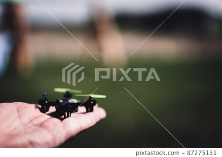Miniature toy remote controlled drone taking off from a hand 87275131