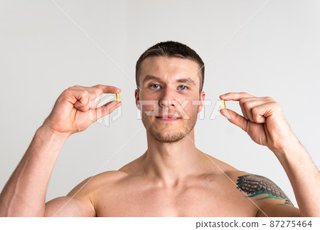 Fish oil is eaten by a man in the hands of vials and a glass bottle pill health healthy, nutrition treatment drug healthcare lifestyle, medication cod. isolated fat, health female giving dieting 87275464