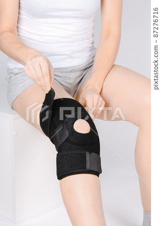 Knee Support Brace on leg isolated on white background. Elastic orthopedic orthosis. Anatomic braces for knee fixation, injuries and pain. Protective knee joint bandage sleeve. Trauma, rehabilitation. 87276716