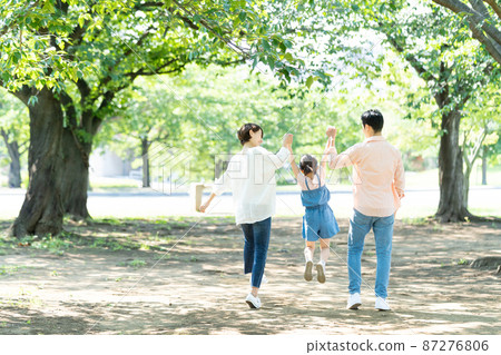 Parent and child holding hands and walking 87276806