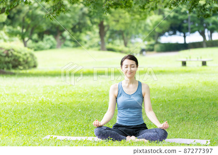 在公園裡做瑜伽的中年婦女 87277397