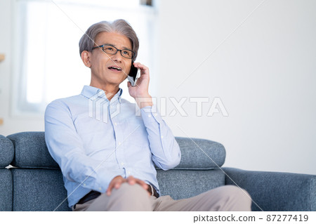 老人坐在沙發上打電話 87277419