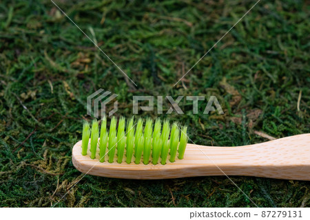 Eco-friendly toothbrush. Toothbrush on a natural background. Moss and grass. Ecology care concept 87279131