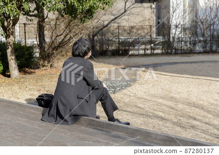A man in a suit standing in the park 87280137