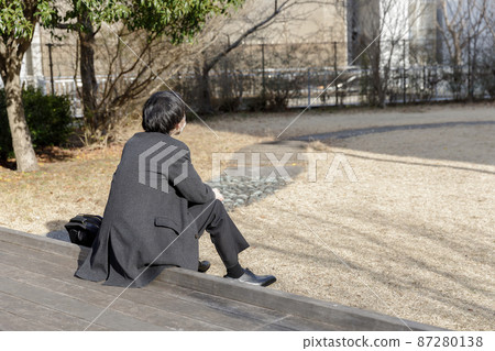 A man in a suit standing in the park 87280138
