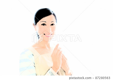 Image of applying hand cream to a middle-aged woman who puts her hands together with a smile in an apron Image of applying hand cream to a middle-aged woman who puts her hands together with a smile in an apron 87280563