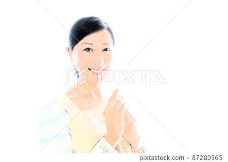Image of applying hand cream to a middle-aged woman who puts her hands together with a smile in an apron Image of applying hand cream to a middle-aged woman who puts her hands together with a smile in an apron 87280565