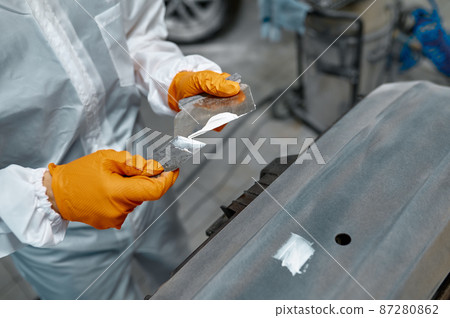 Mechanic engaged in local repairing car body 87280862