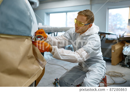 Technician wrapping car with paper before painting 87280863