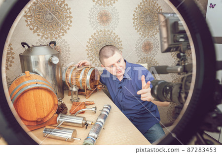 Young White Man Blogs About Distillation and Whiskey Production at Home 87283453